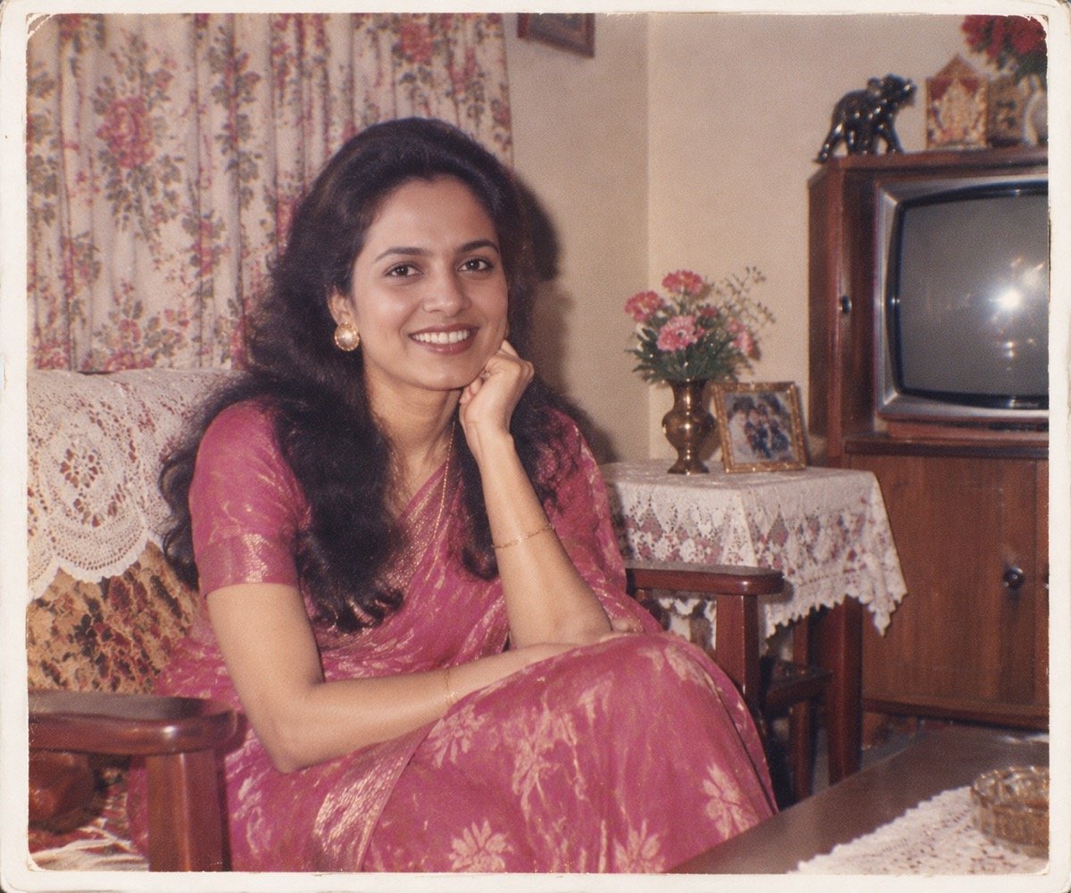 ChatGPT result for prompt 4: a woman in a pink saree in a 1980s Indian living room with a cabinet TV