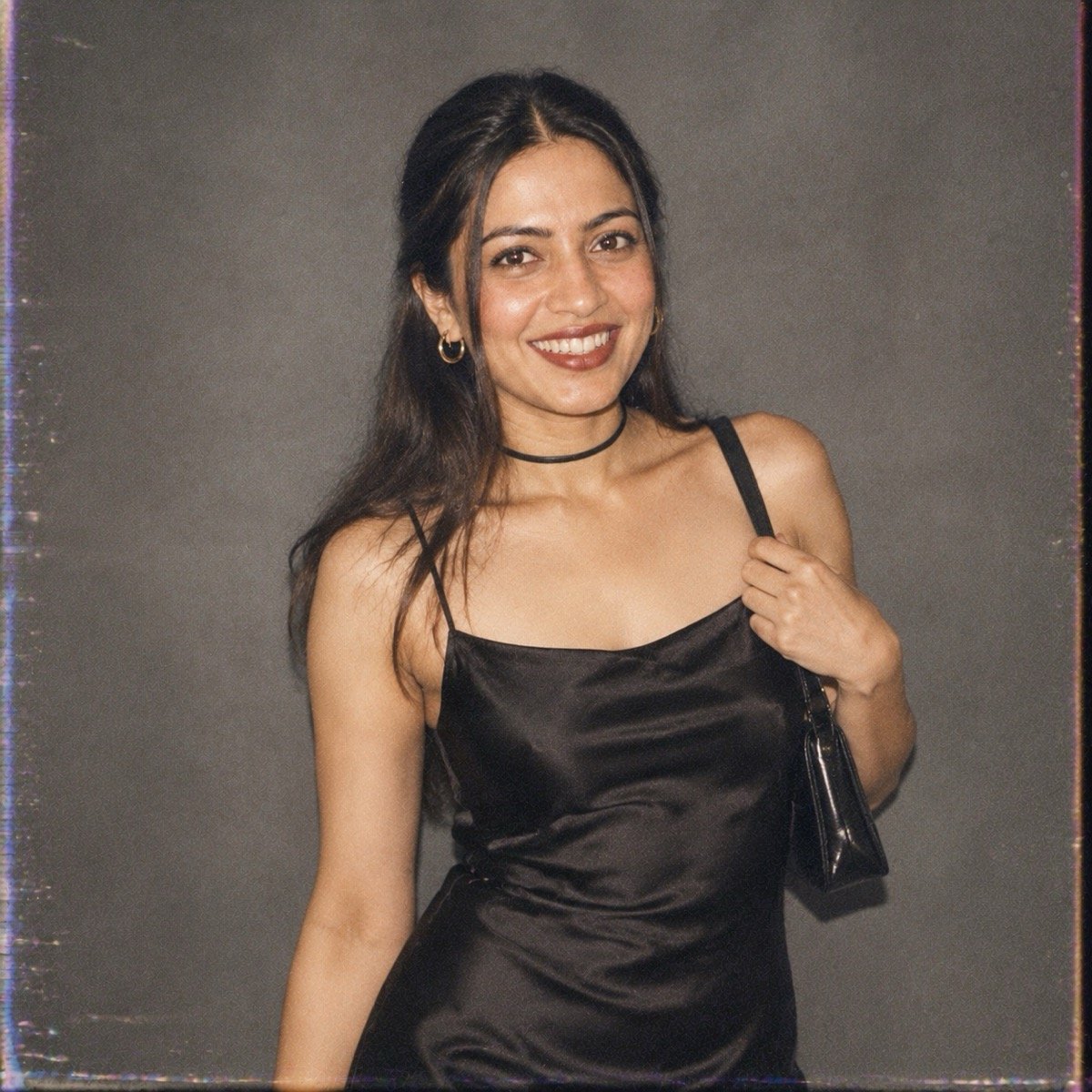 ChatGPT result for prompt 12: a woman in a black satin slip dress against a grey backdrop in a 1990s editorial portrait