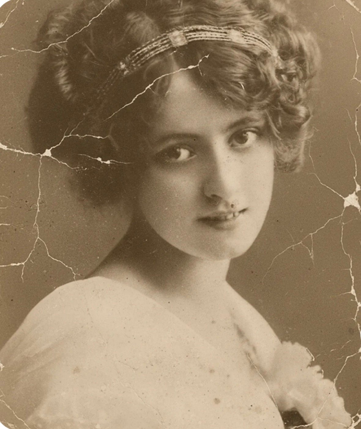 Antique sepia studio portrait covered in heavy cracks and surface damage